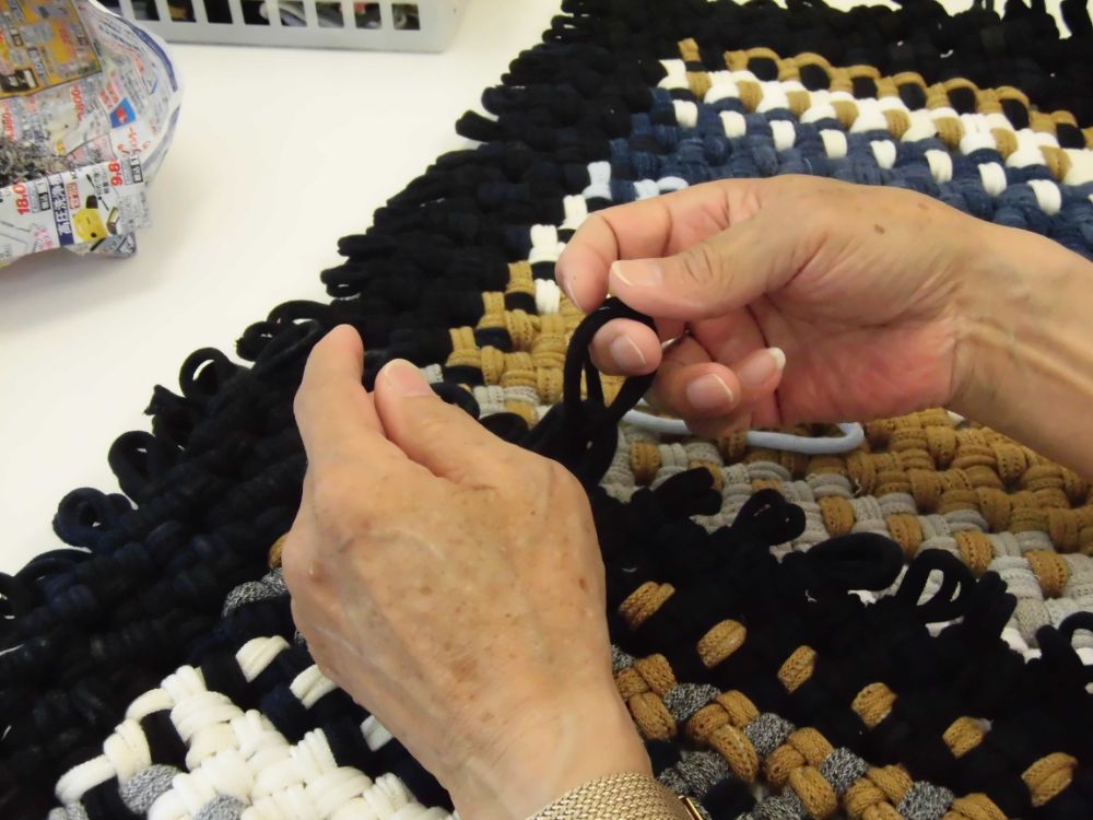 色とりどりの紐を編んでいる手元のアップ