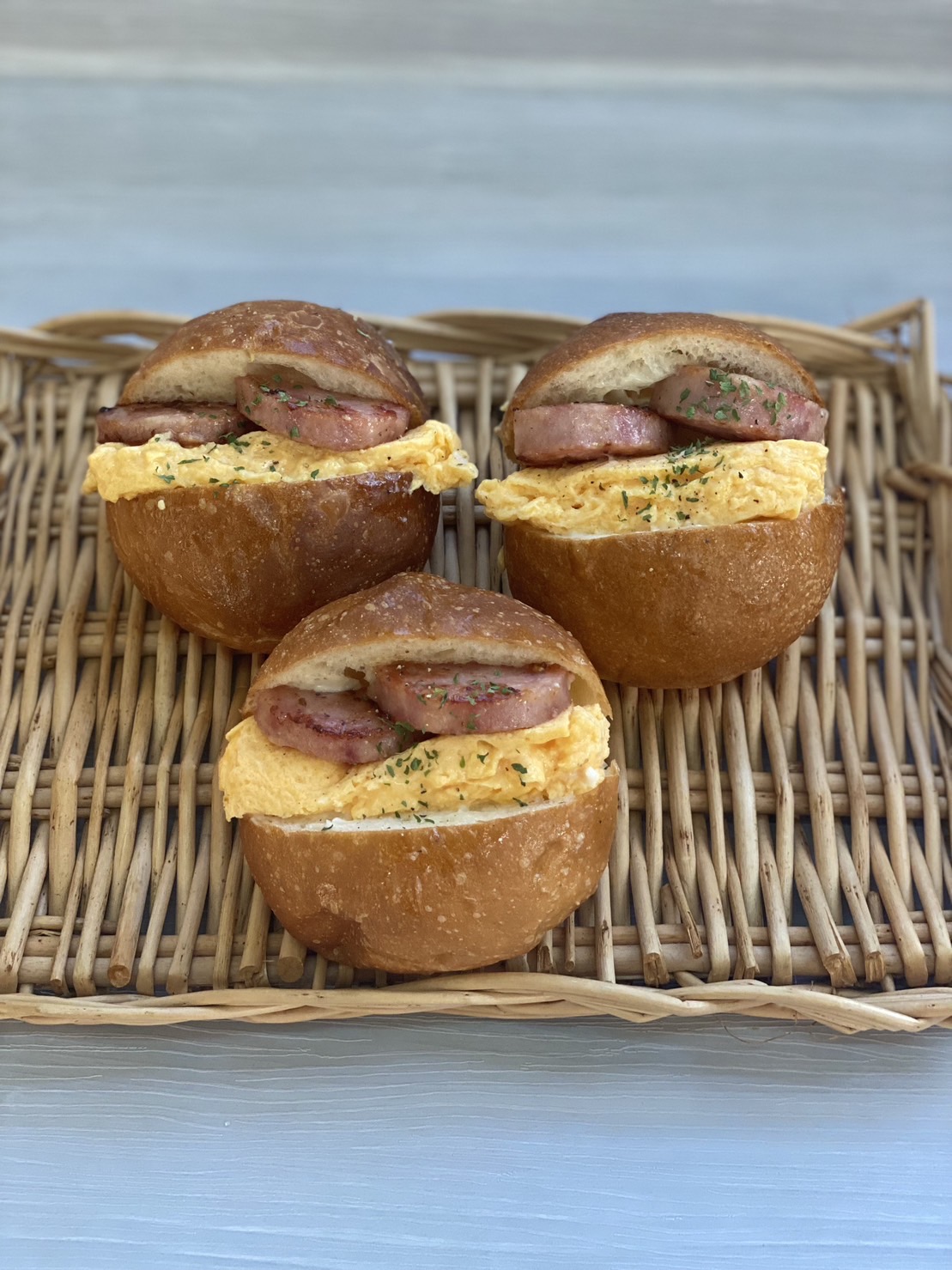 丸いパンで輪切りソーセージとオムレツを挟んでいる